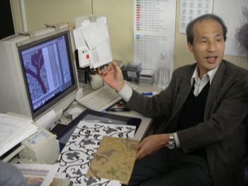 織物設計にしたがって、方眼紙に図案を拡大して写し、繊維別に色を変えて、一目一目、たんねんに塗り分けしていきます。