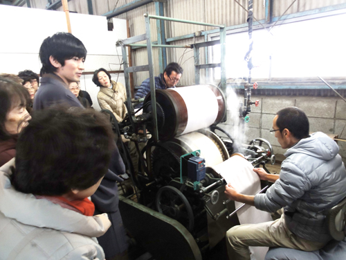 湯通しで縮んだ反物の幅だしをする作業。